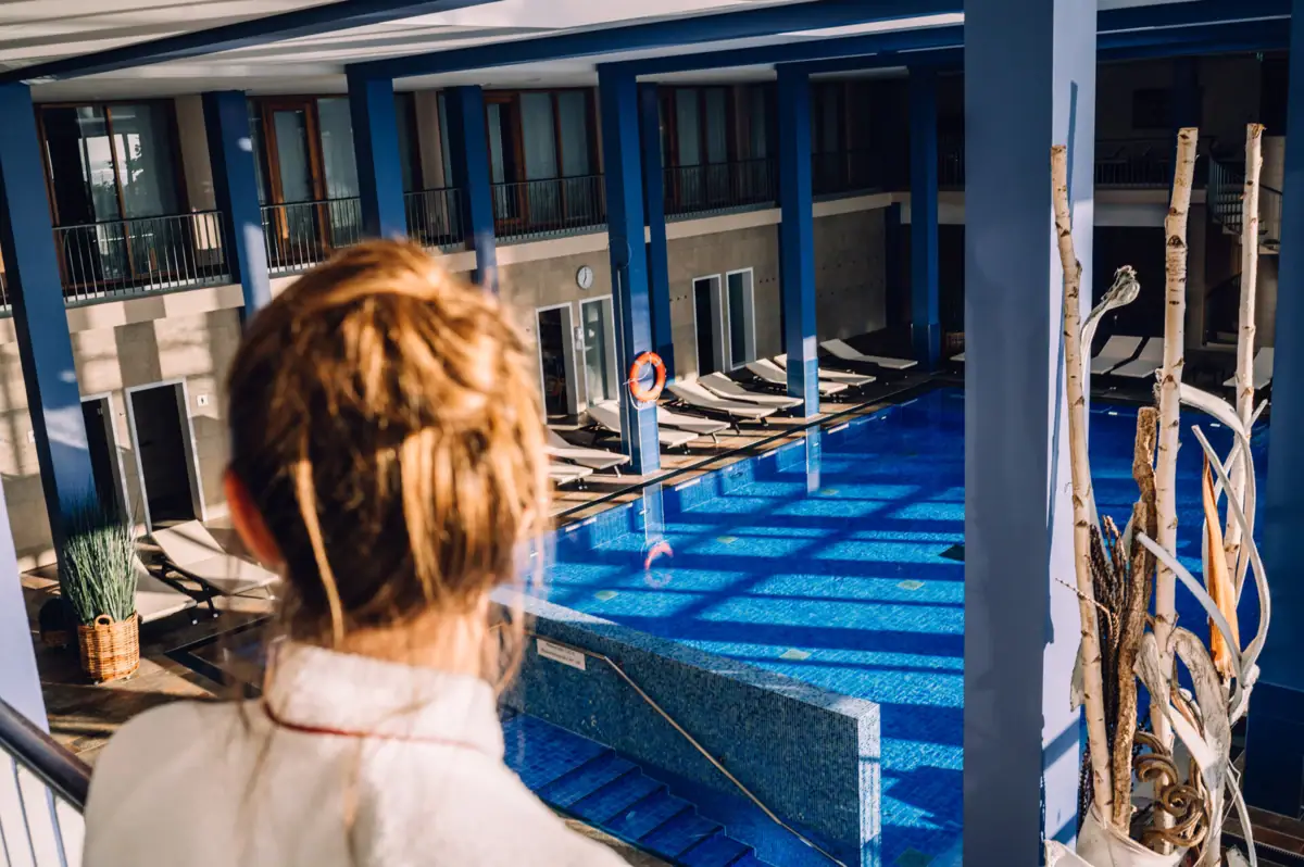 Eine Person blickt auf einen Swimmingpool.