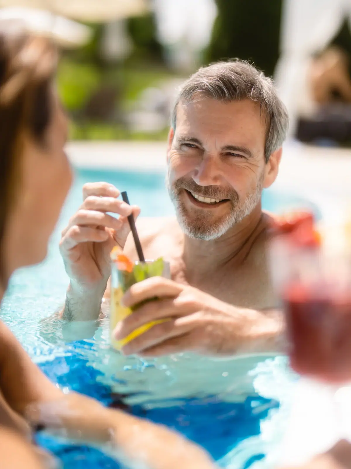 Un uomo e una donna sorridenti in piscina.