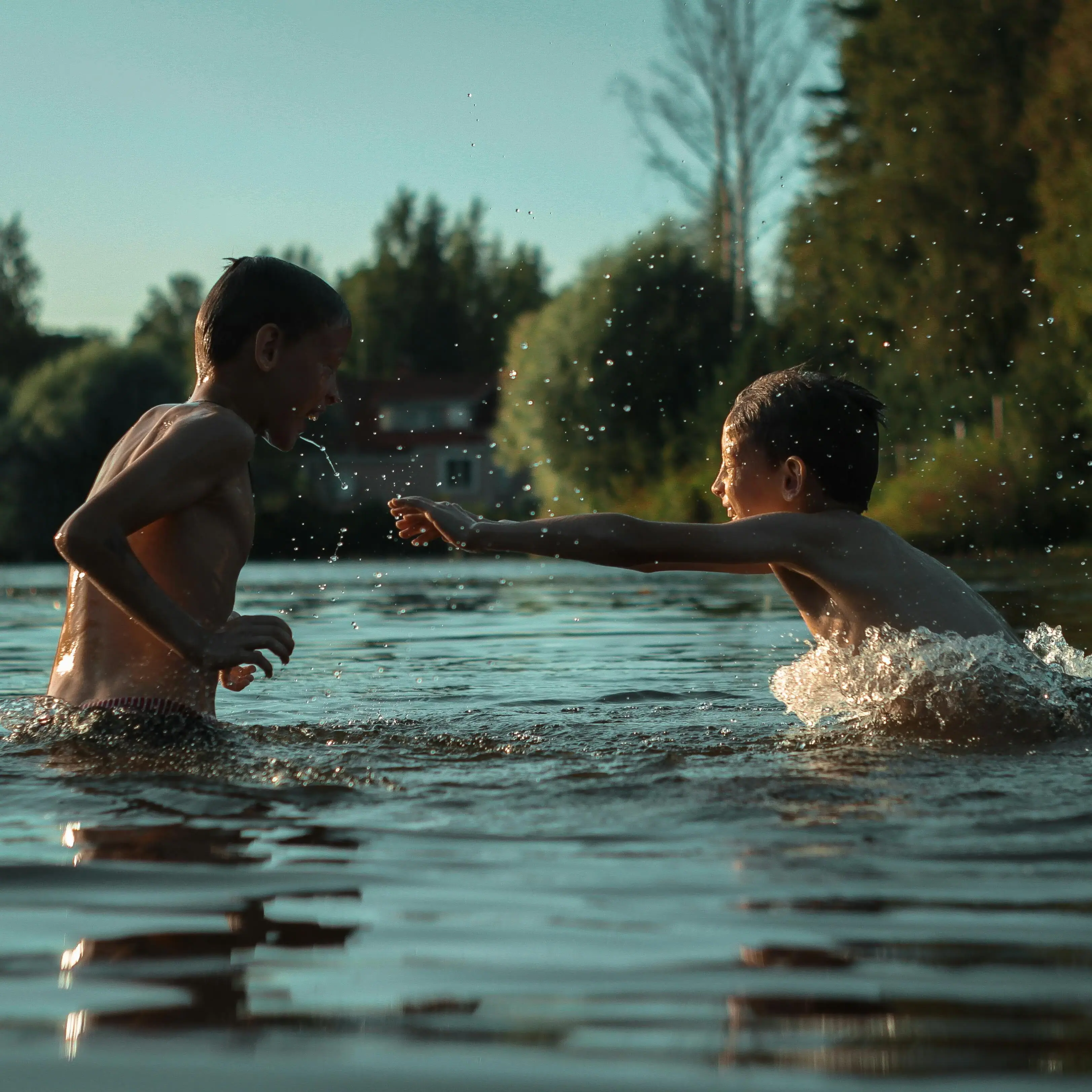Zwei Jungen spielen im Wasser.