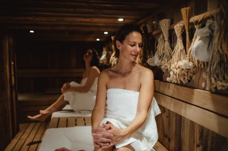 Donna in abito da sposa seduta in una sauna.