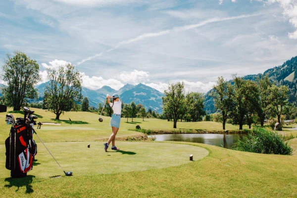 Donna che gioca a golf su un campo erboso.