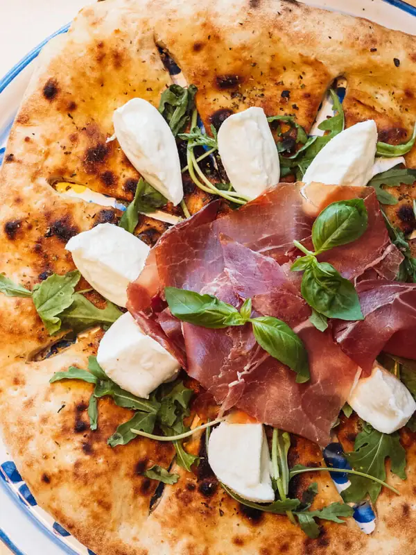 Pizza con carne e formaggio su un piatto.