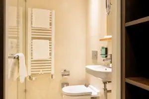 Bagno con doccia a vetri e lavabo.
