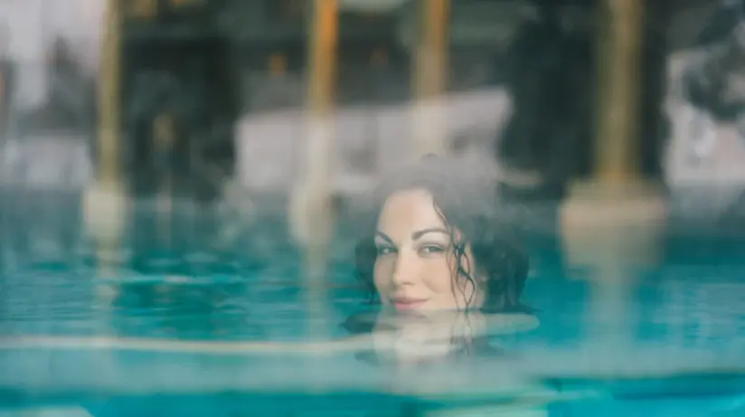 Donna che nuota in una piscina all'aperto.