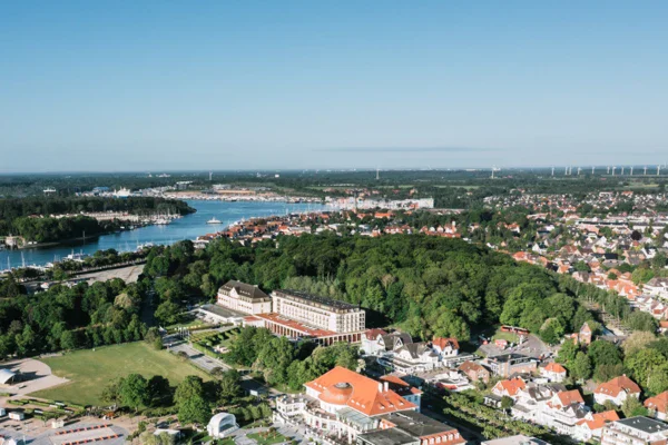 Vista aerea di una città con edifici e alberi, caratterizzata da un design urbano e aree residenziali.