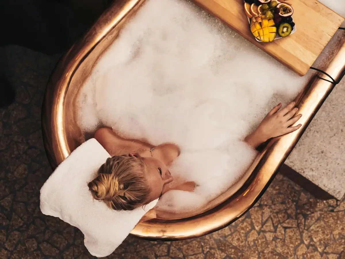 Donna in una vasca da bagno con schiuma.