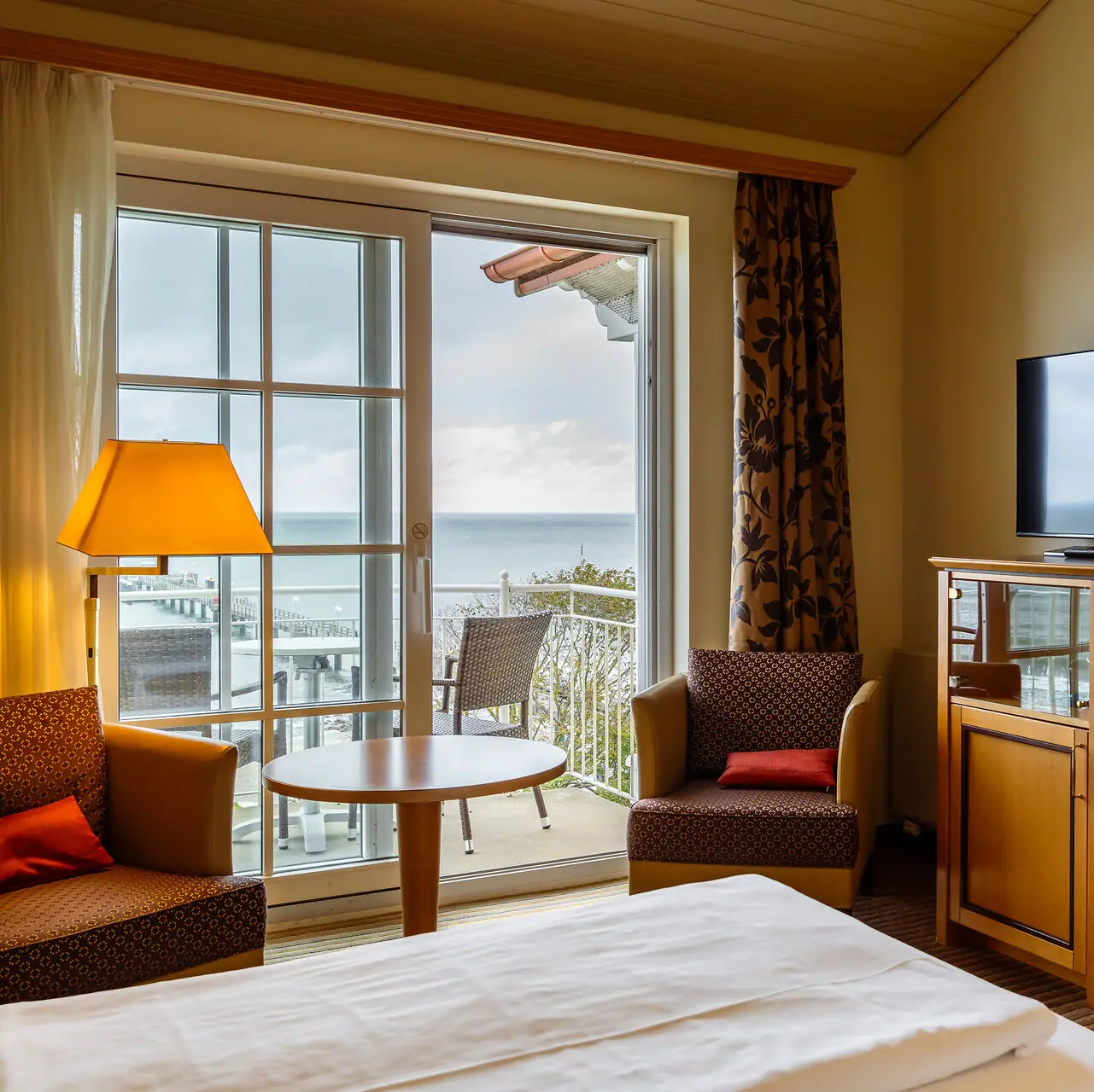 Una camera d'albergo con televisione e tavolo.