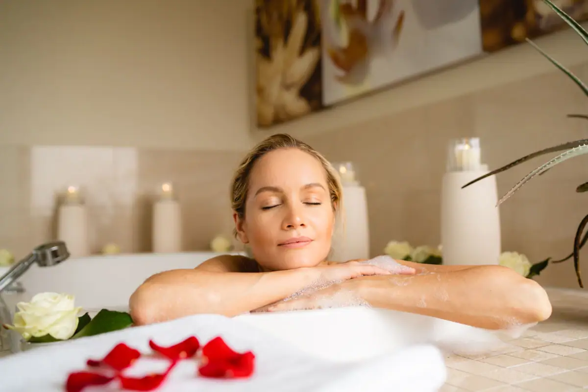 Eine Frau mit geschlossenen Augen in einer Badewanne.