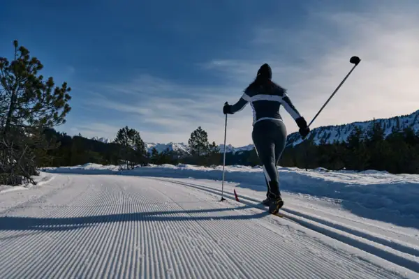 Eine Person beim Skifahren auf einer verschneiten Straße.