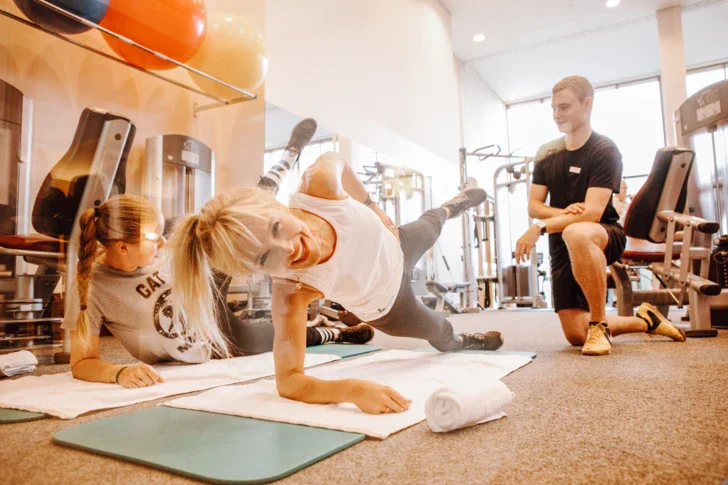 Donna che fa una plank su un tappetino in palestra.