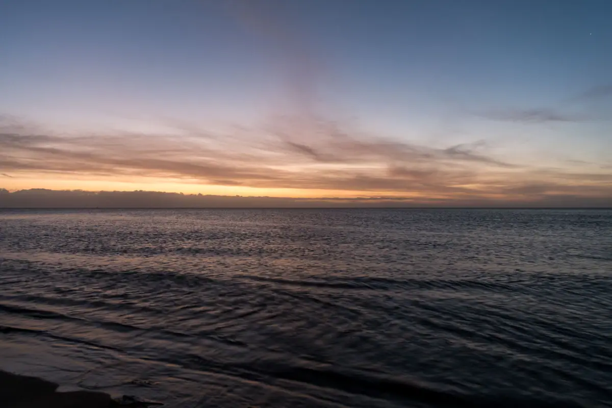 Acque al tramonto con nuvole nel cielo