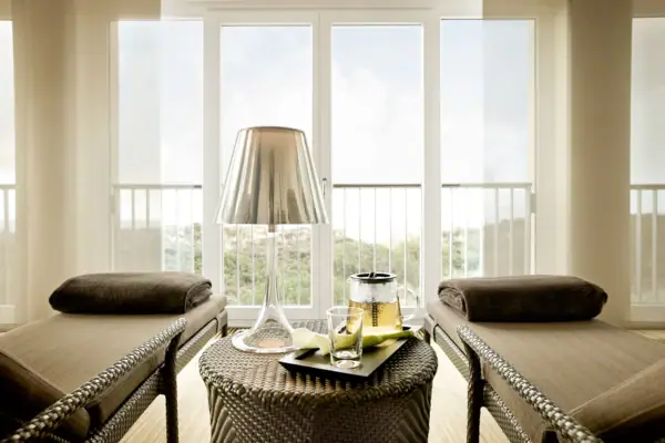 Ein Tisch mit einer Lampe und einem Glas darauf.