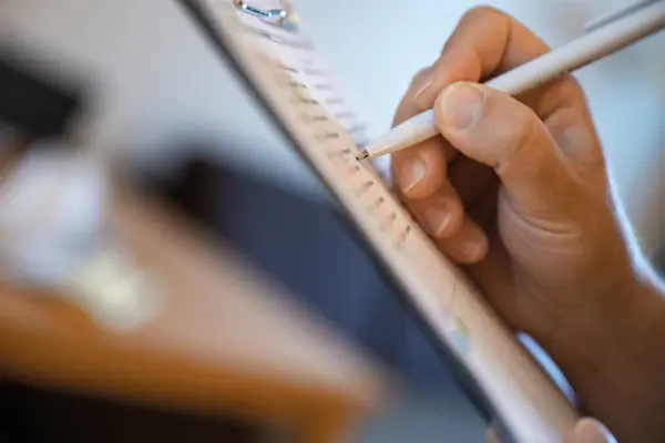 portablocco Una persona sta scrivendo con una penna su un blocco con fermaglio.