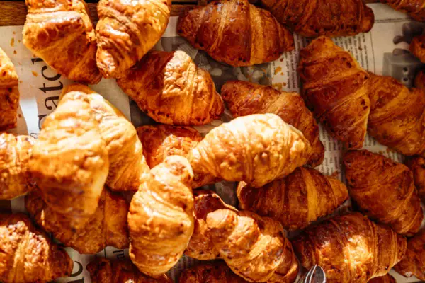 Colazione a Travemünde Un gruppo di croissant su un foglio di giornale.
