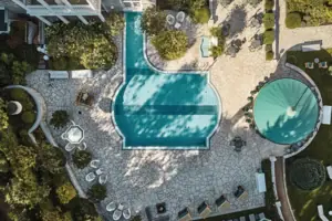 Piscina in giardino con alberi sullo sfondo.