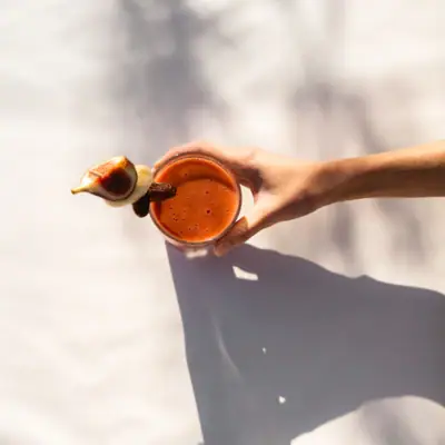 Eine Hand hält ein Glas Smoothie.