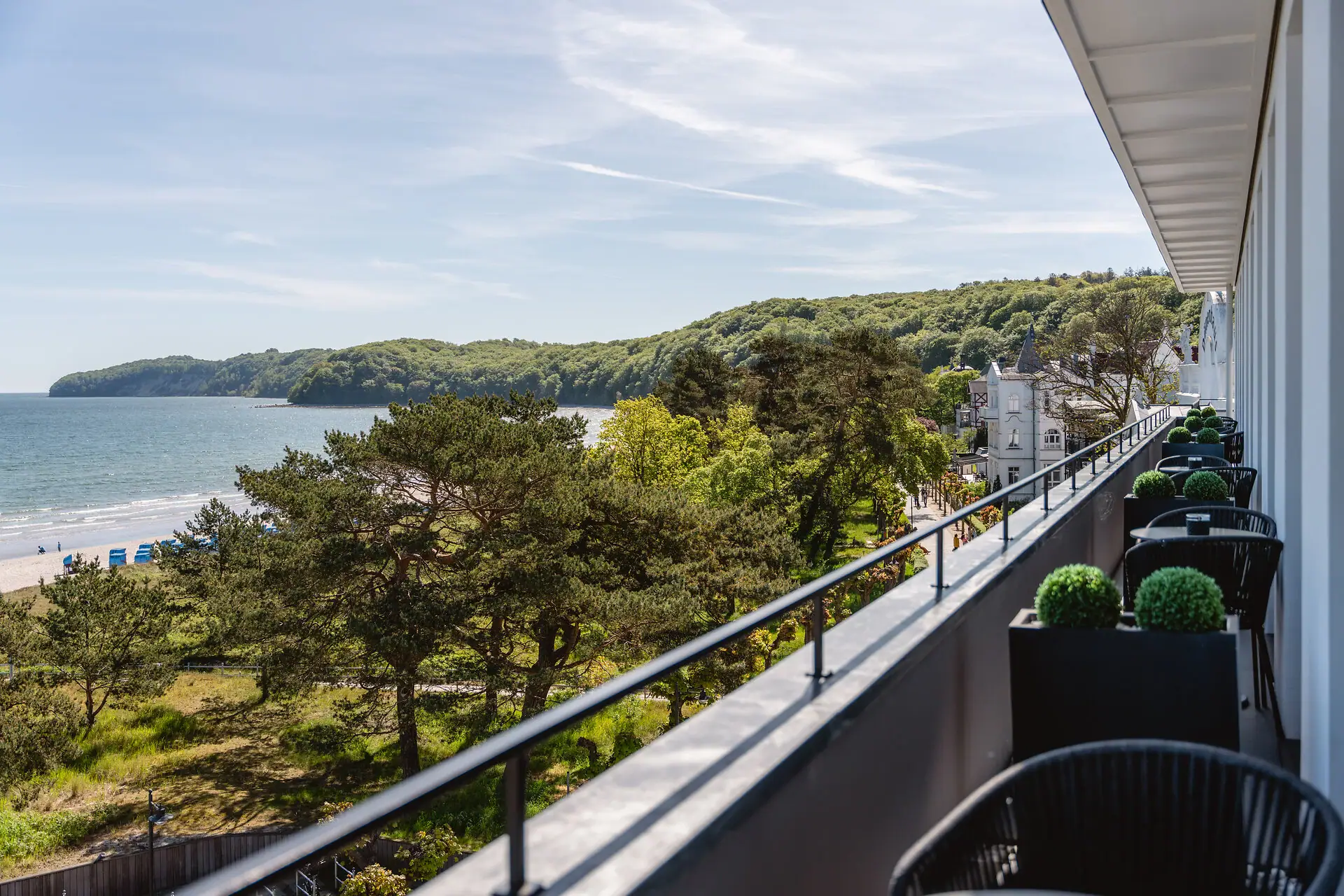 Balkon mit Blick auf einen See unter wolkenbedecktem Himmel.