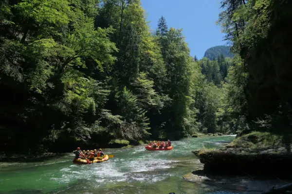 Eine Gruppe von Menschen in Schlauchbooten auf einem Fluss.
