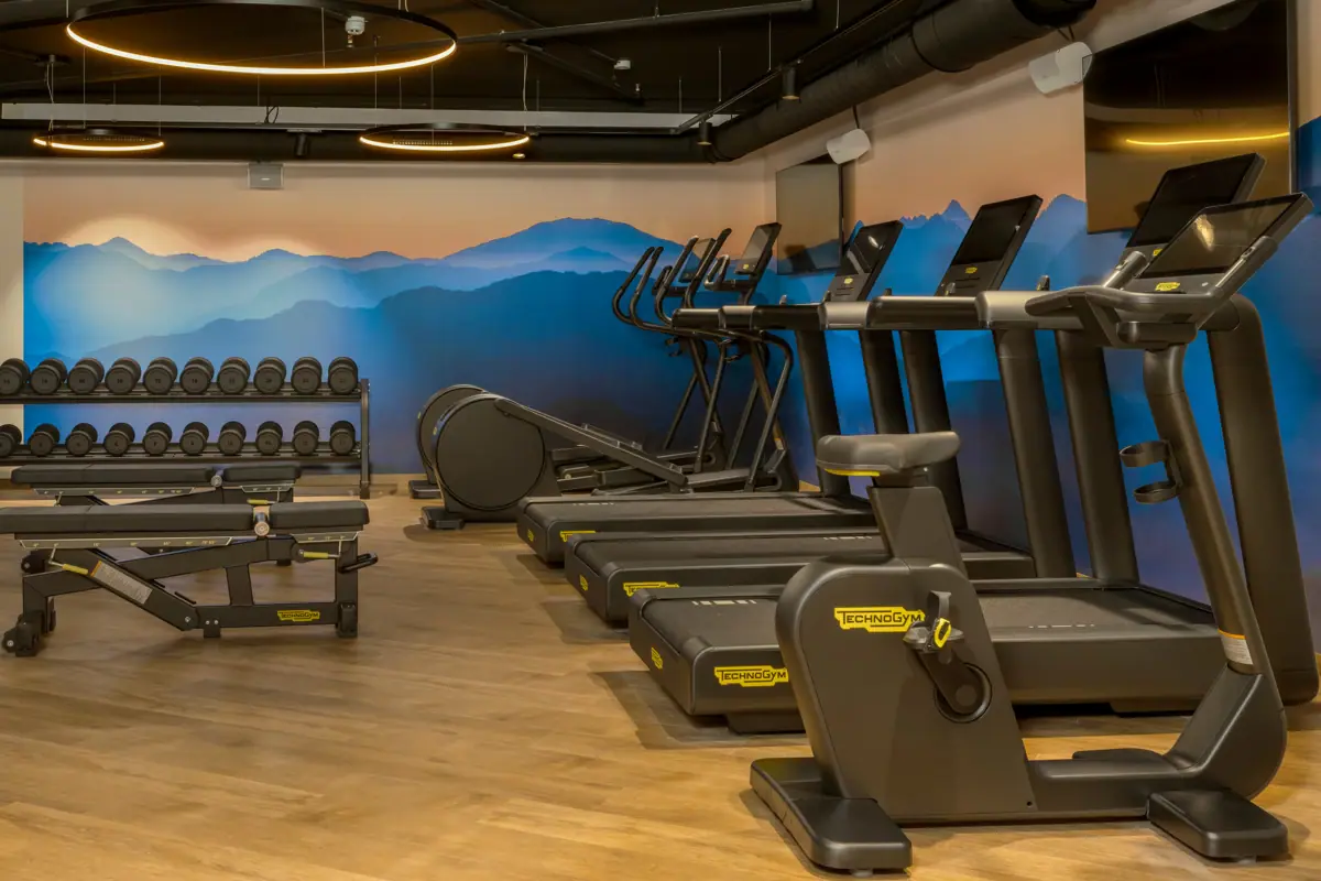 Un centro fitness con tapis roulant e attrezzature per l'allenamento.