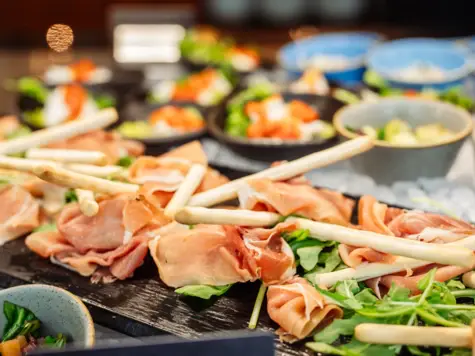 Piatto di cibo con bastoncini di legno, comprendente frutti di mare e verdure.