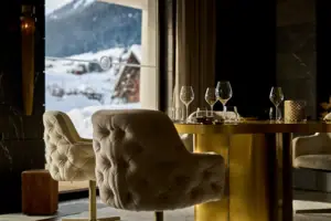 Un tavolo con dei bicchieri da vino e una vista su una montagna innevata.