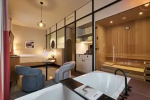 Una stanza con vasca da bagno, sauna e letto.