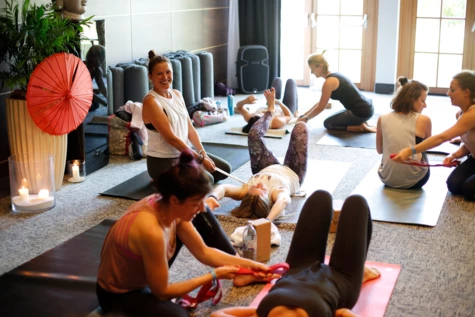 Un gruppo di donne sedute in una stanza che praticano yoga.