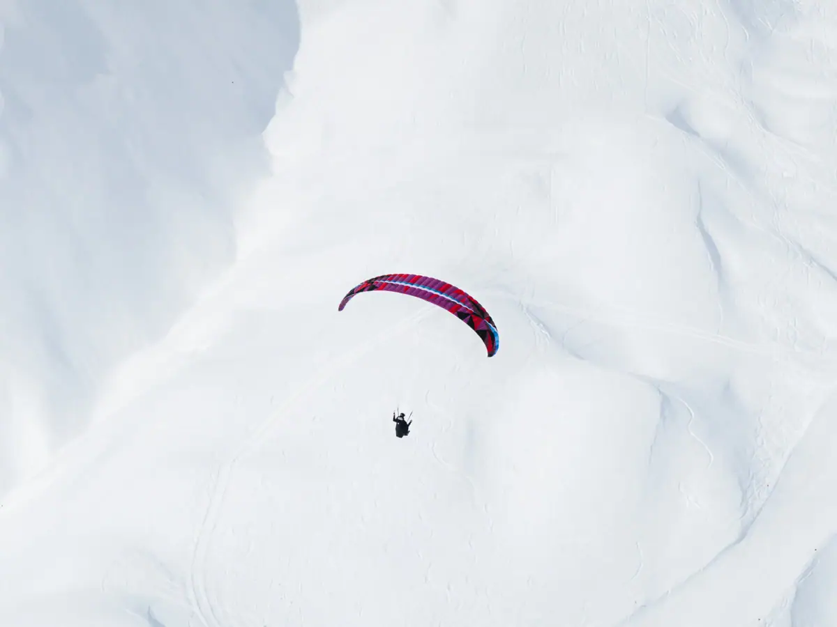 Una persona che fa paracadutismo sulla neve.