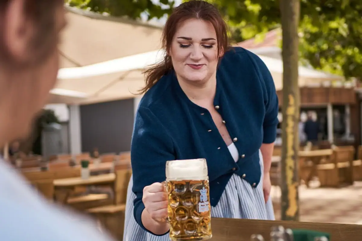 O zapft is' - auch auf Rügen findet sich bayrischer Flair. Eine Wirtin serviert eine Maß Bier in einem Biergarten