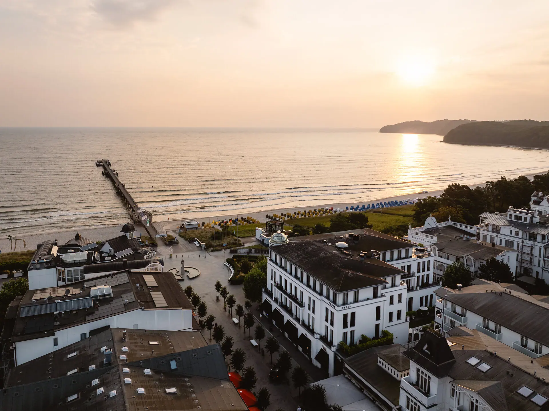 Una spiaggia con degli edifici e un molo.