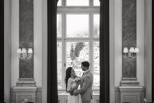 Un uomo e una donna in piedi in una stanza con una finestra.