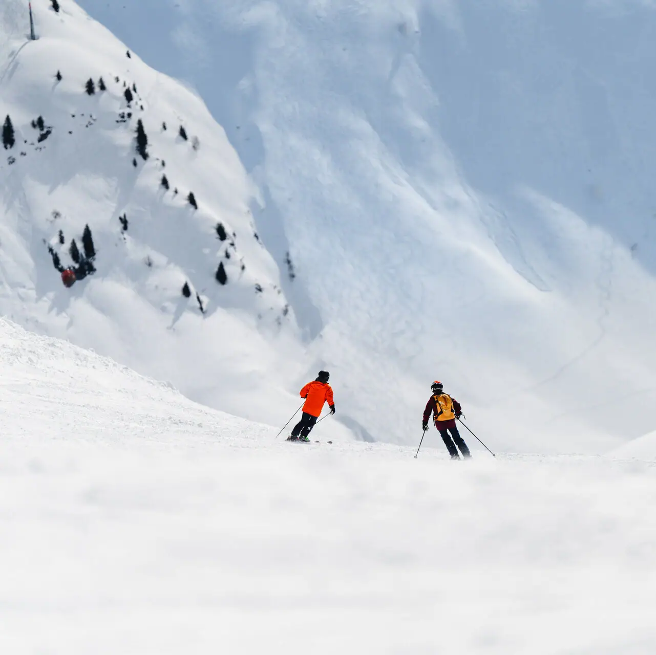 Zürs Un gruppo di persone che scia giù per una montagna innevata.