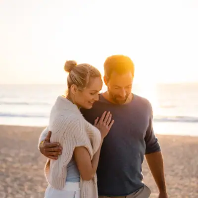 Un uomo e una donna si abbracciano sulla spiaggia.