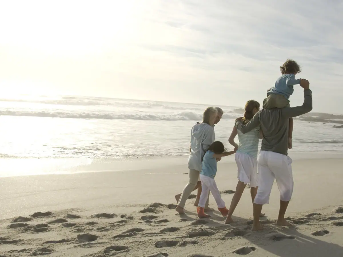 Eine Familie spaziert am Strand.