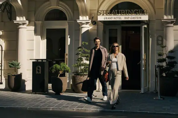 Ein Mann und eine Frau gehen vor einem Hotel spazieren.