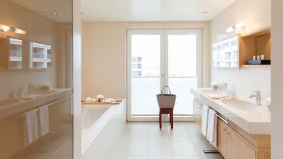 Un bagno luminoso e moderno con un grande lavabo, una vasca da bagno e una doccia.