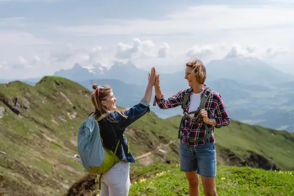 Zwei Frauen geben sich im Freien ein High Five.