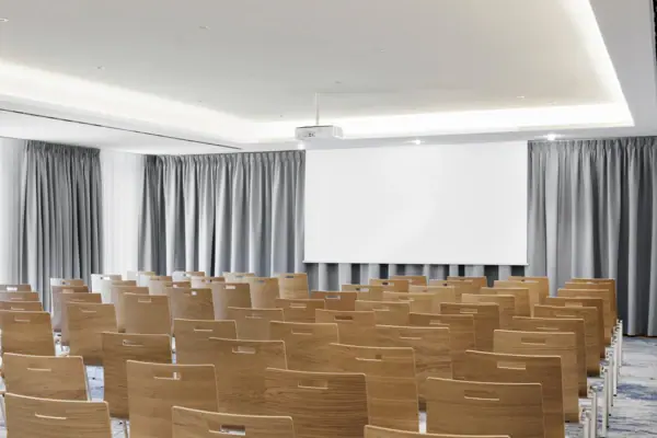 Sala per eventi dotata di proiettore e schermo. Una sala conferenze presso l'A-ROSA Tegernsee, dotata di file di sedie, un proiettore e uno schermo.