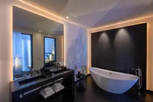 Bagno con vasca e lavabo, dotato di accessori moderni e specchio.