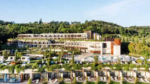 Un hotel dal design moderno che si inserisce con eleganza in un paesaggio naturale. L'architettura a terrazze offre ampie vedute da ogni piano e integra spazi verdi sui tetti. Due piscine e giardini accuratamente curati invitano gli ospiti a rilassarsi, mentre il verde degli alberi circostanti offre uno sfondo rilassante.