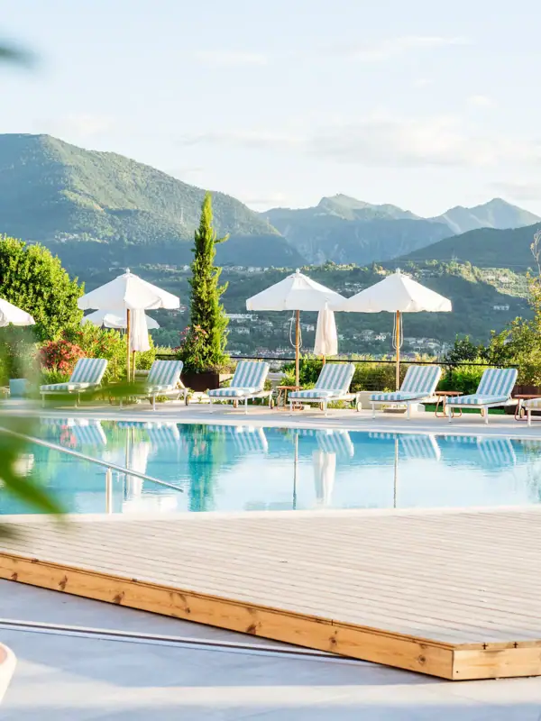 Ein Außenpool mit Liegestühlen und Sonnenschirmen.