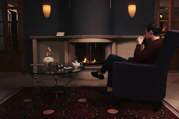 Lobby-Bar Ein Mann sitzt in einem Stuhl und trinkt aus einer Tasse.