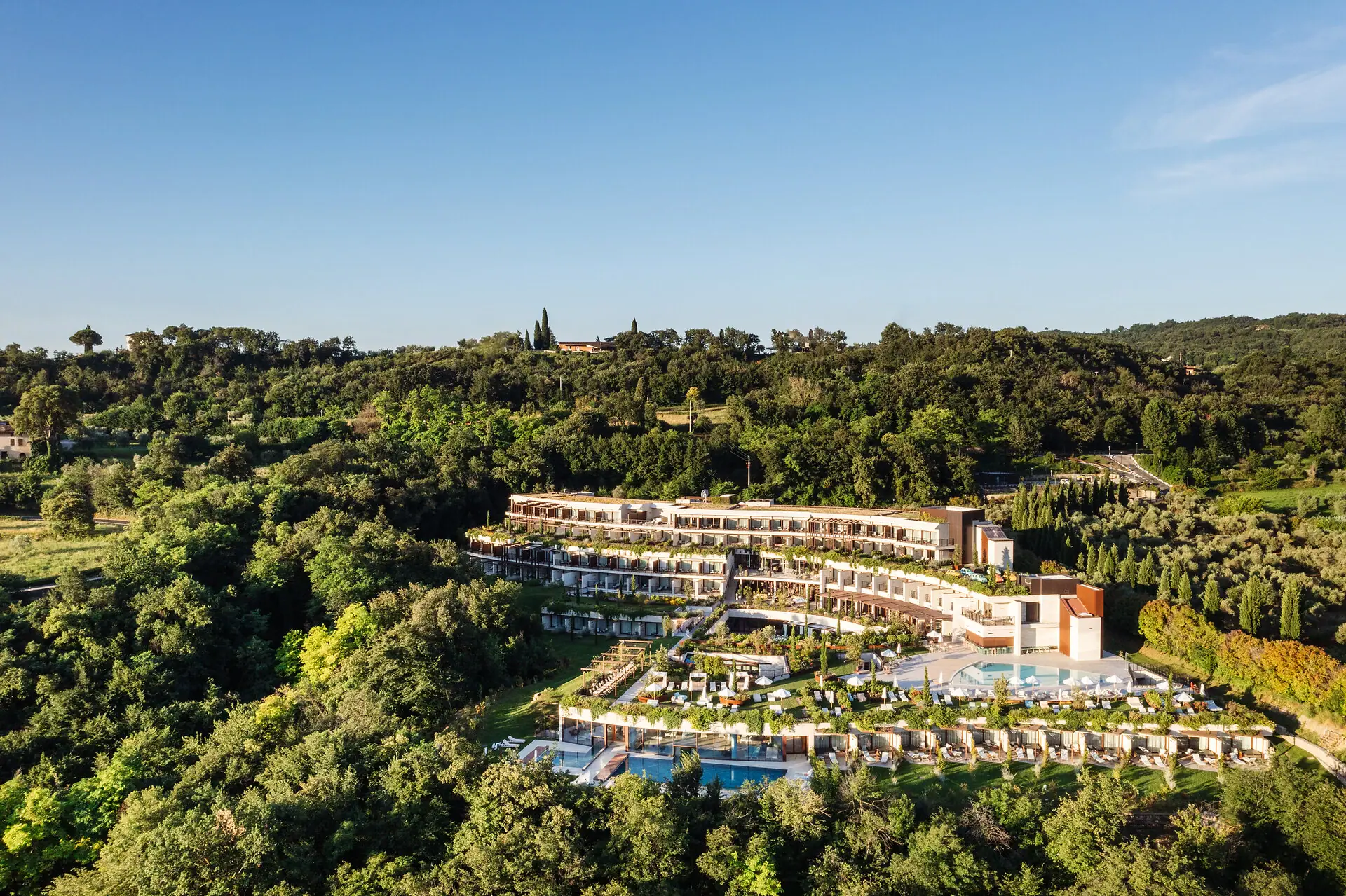 Un edificio con piscina circondato da alberi.