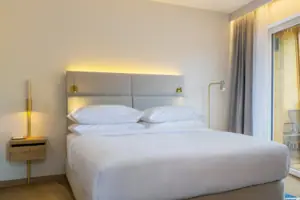 zona notte Un letto in una camera con lenzuola e cuscini eleganti.