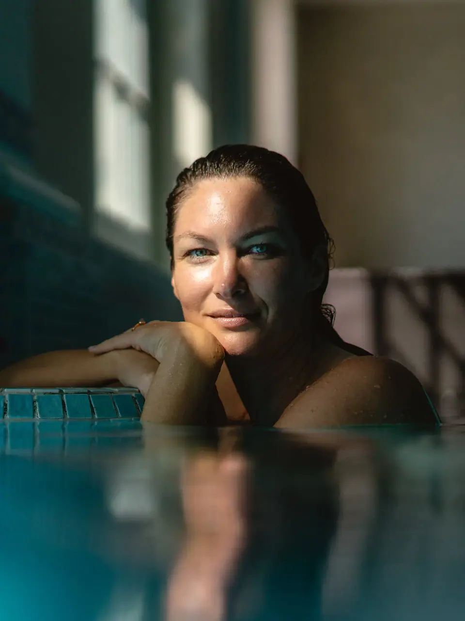 Una donna sta nuotando in una piscina coperta.