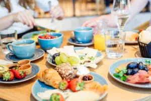 Frühstück Ein Tisch mit Tellern voller Speisen und Gläsern mit Wasser.