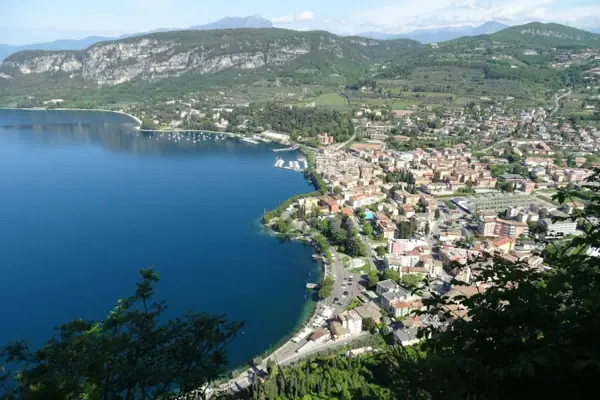 Garda Città sulle rive di un corso d'acqua vista dall'alto, con le montagne sullo sfondo.
