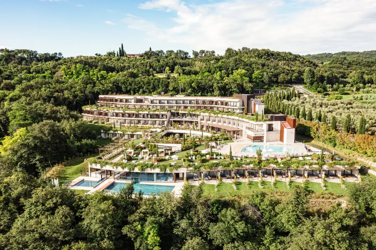 A-ROSA Hotel Lago di Garda Un edificio con una piscina, circondato da alberi.