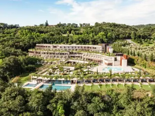 Edificio con diverse piscine circondato da alberi.