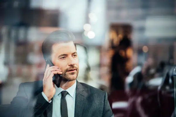 Ein Mann im Anzug telefoniert mit einem Handy.